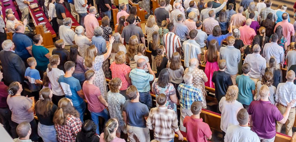 A congregation standing in the pews during a church worship service