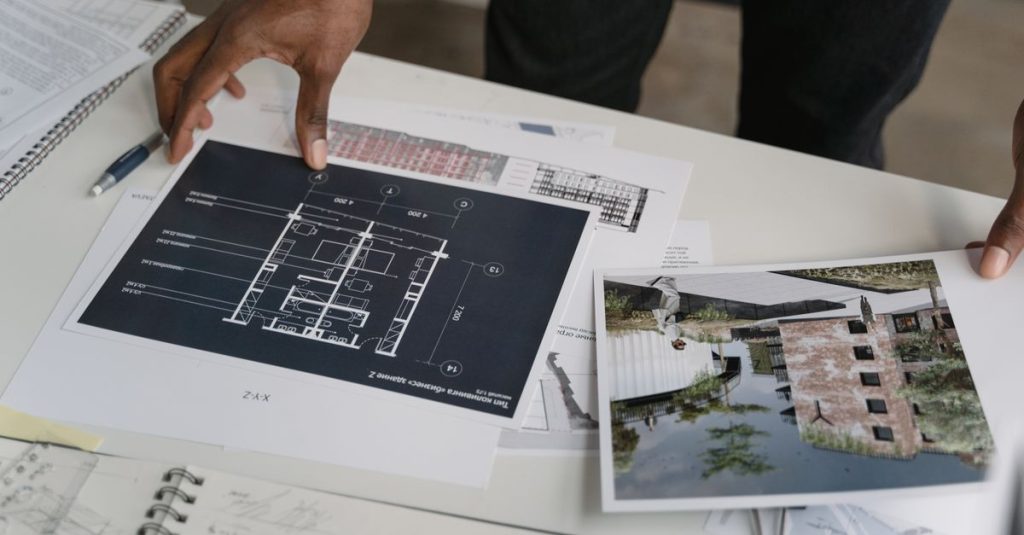 Architect reviewing a floor plan and building design on a desk