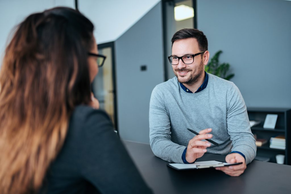 Job interview: a hiring manager speaking with a candidate across a desk