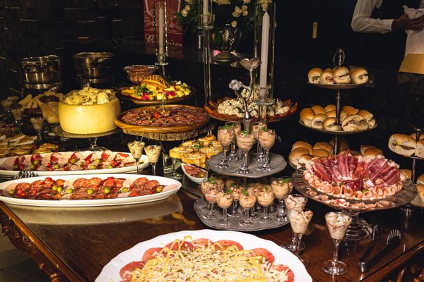Catering buffet table with plated dishes, charcuterie and appetizers at an event