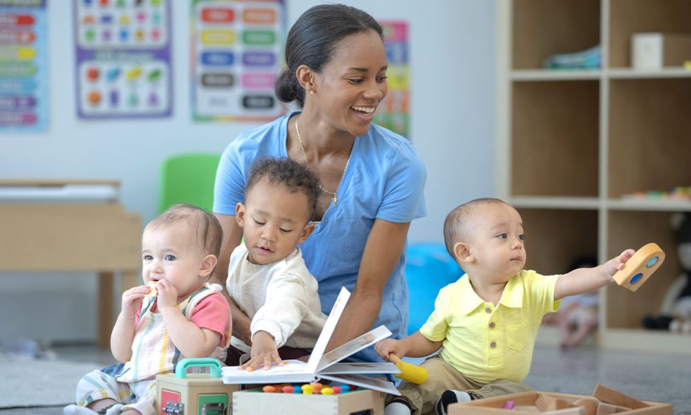 Childcare teacher reading with toddlers in a daycare classroom