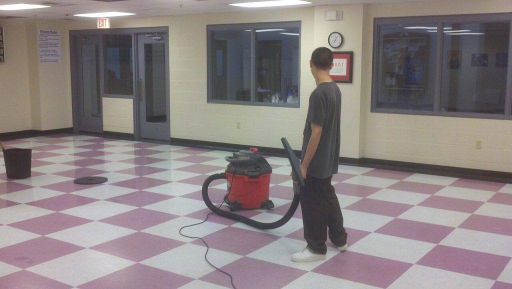 Janitorial worker vacuuming a commercial floor