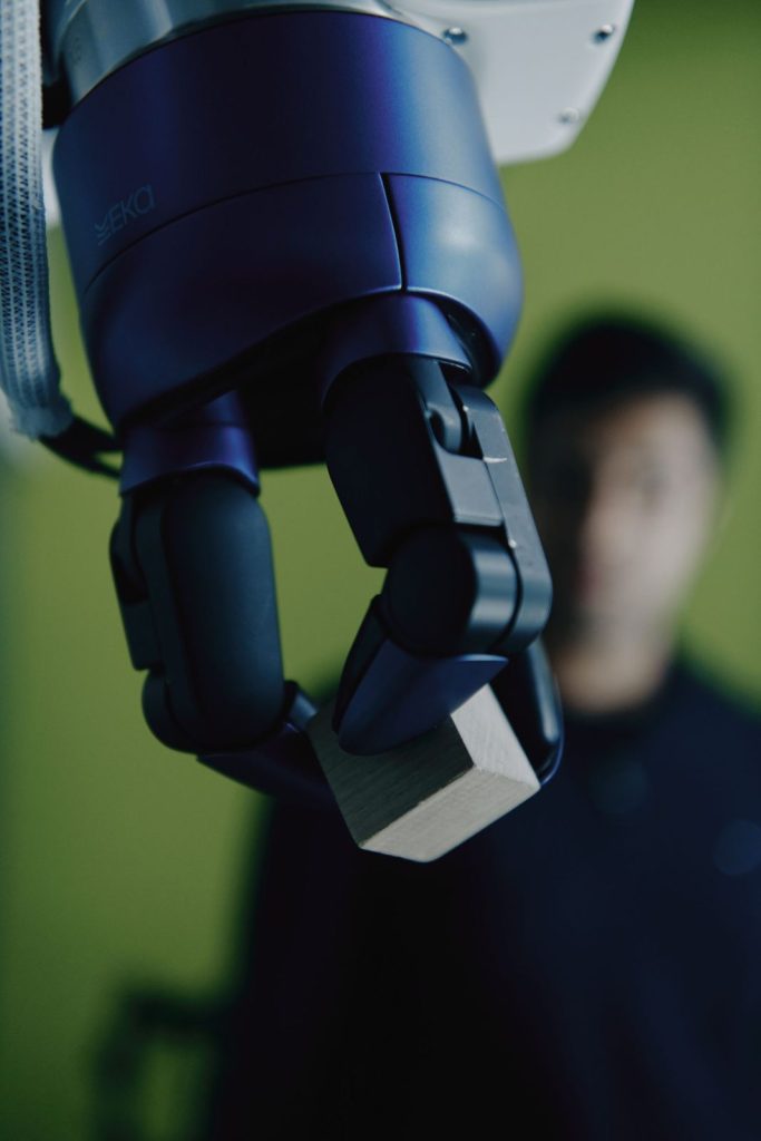 Eka Robotics force-sensitive gripper holding a wooden block