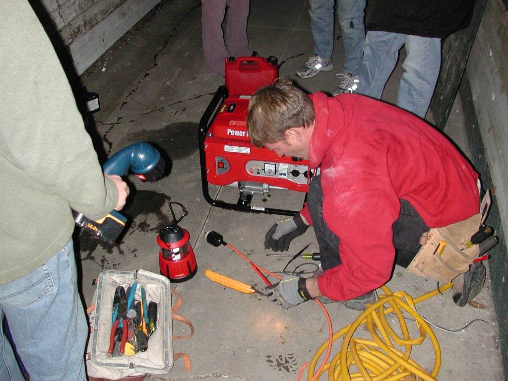 Electrician working with tools and a generator on a job site