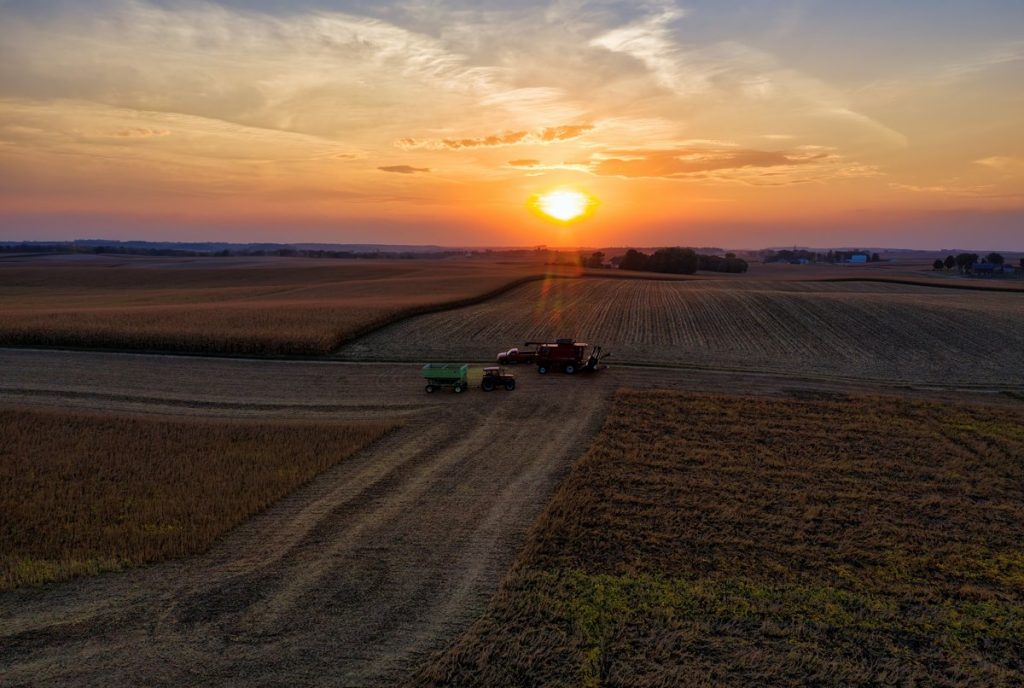 Aerial view of harvest equipment in a field at sunset