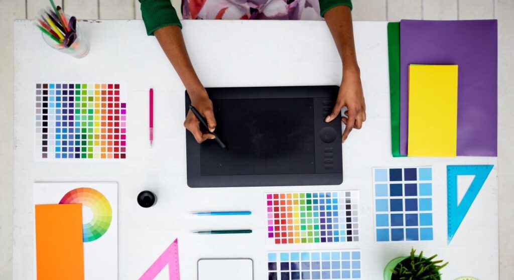 Graphic designer working on a drawing tablet with color swatches