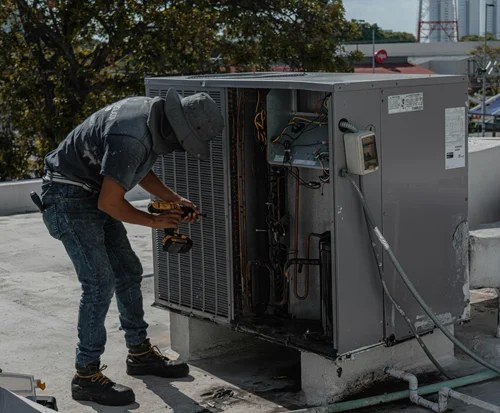 HVAC technician servicing a rooftop air conditioning unit