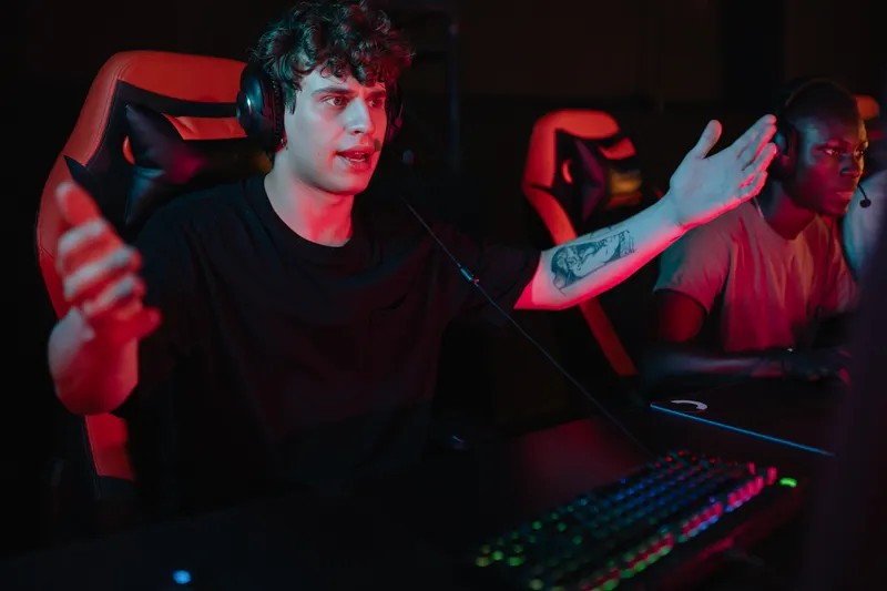 Live streamer wearing a headset at a gaming PC with an RGB keyboard