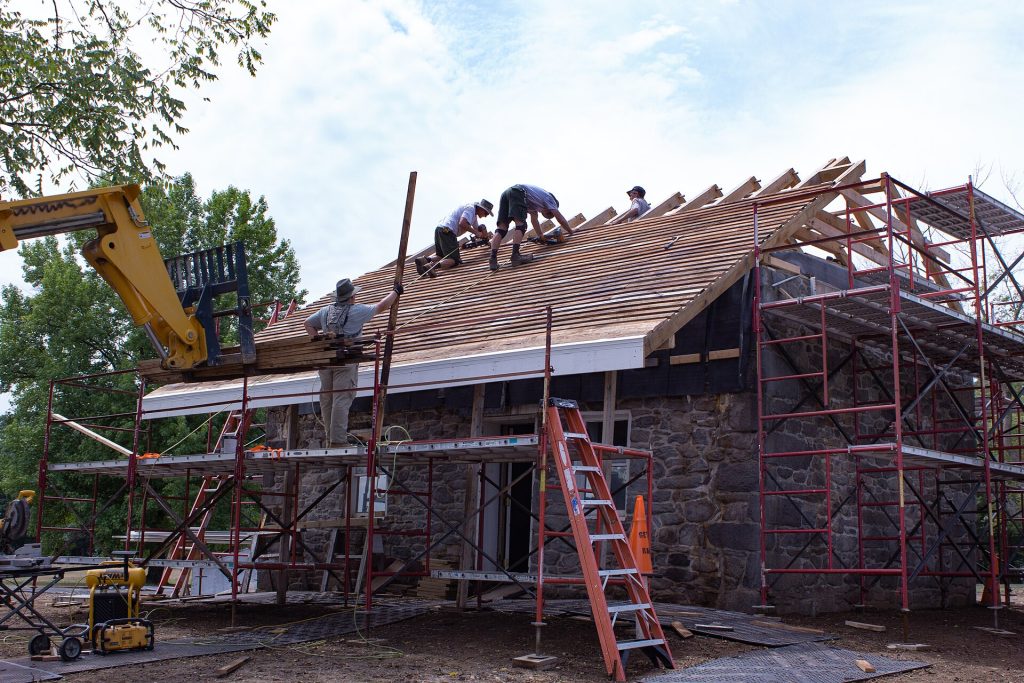Roofing crew installing cedar shingles on a roof