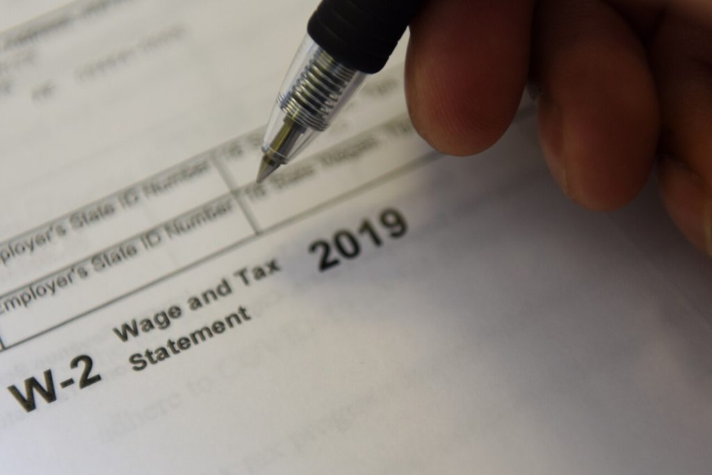 Close-up of a pen filling in a W-2 wage and tax statement form