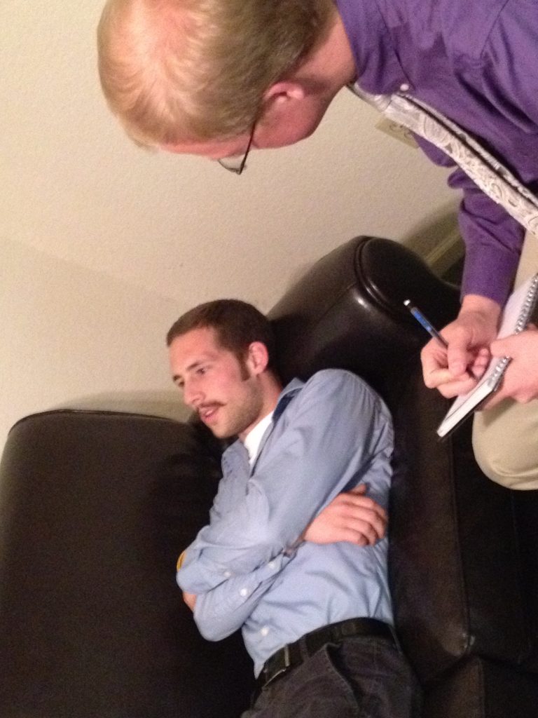 Therapist taking notes during a session with a client on a couch