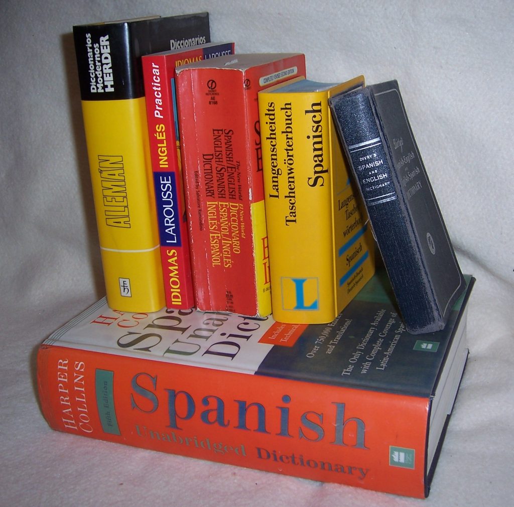 A stack of bilingual dictionaries in Spanish, English, and German